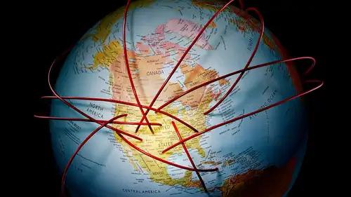 A globe crossed by red lines running between continents